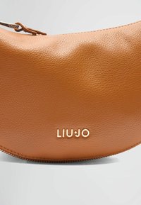 Geantă din piele maro, tip crossbody, cu o siluetă rotunjită, având un logo auriu "LIU JO" și închidere tip fermoar cu un accesoriu de fermoar în nuanță aurie.