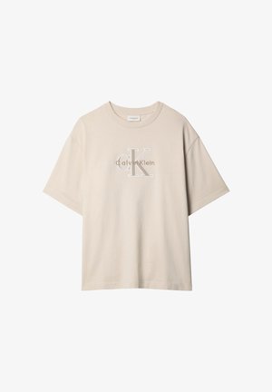 T-shirt beige a maniche corte oversize con logo "Calvin Klein" e grande logo "cK" ricamati in bianco e marrone al centro davanti.