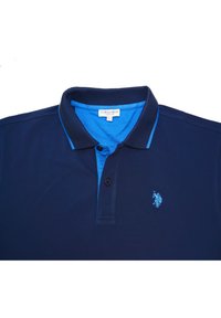 Marineblaues Polohemd mit hellblauem Kragen und innerer Knopfleiste. Verfügt über ein kleines, gesticktes Logo auf der linken Brustseite und drei Knöpfe.