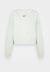 Světl zelený zkrácený svetr vyrobený z měkké látky. Má kulatý výstřih, dlouhé rukávy a malé černé logo Nike na hrudi.