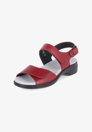 Sandale rouge à bout ouvert avec des sangles réglables sur le pied et autour de la cheville, avec une semelle intérieure rembourrée gris clair et une semelle basse noire.