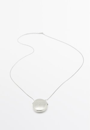 Collana con pendente in argento caratterizzata da un pendente ovale opaco su una catena sottile. Design semplice con una superficie liscia e hardware minimale.
