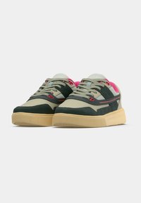Grüne und beige Sneaker aus Wildleder und Mesh-Materialien, mit rosa Akzenten, einer strukturierten Zehenkappe und einer Gummisohle.