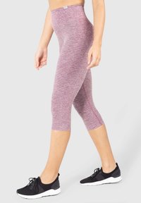 Leggings in un tessuto rosa mélange, design a vita alta con una superficie liscia, lunghezza cropped, abbinati a scarpe sportive nere.