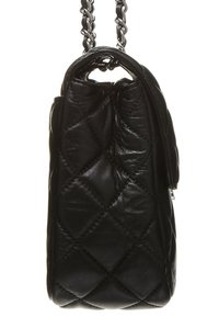 Borsa a tracolla in pelle nera trapuntata con una forma strutturata, dotata di una maniglia a catena e una chiusura con zip sul lato. Finitura testurizzata.