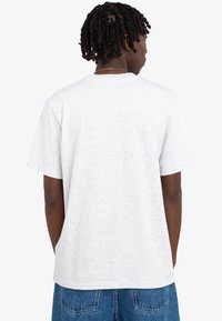 Szara bawełniana koszulka z krótkimi rękawami, prostym krojem i okrągłym dekoltem. Charakteryzuje się gładką teksturą, bez widocznych grafik czy ozdób.