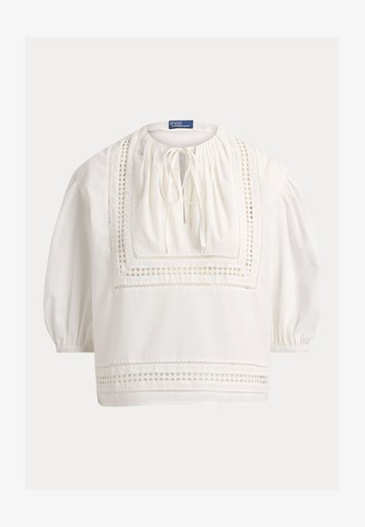 Λευκό μπλούζα με μακριά μανίκια, τετράγωνες λεπτομέρειες δαντέλας, στρογγυλεμένος λαιμός με δέσιμο και ελαστικά μάνικα.
