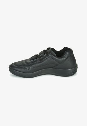 Chaussure de sport en cuir noir avec un bout arrondi, une tige texturée et des sangles ajustables pour la fermeture. Semelle rembourrée et design élégant.