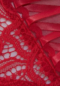 Rote Spitze kombiniert mit strukturiertem Netz. Verfügt über Ripsbanddetails entlang der Kanten, die filigrane Muster und verschiedene Spitzenwebarten hervorheben.