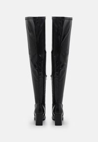 Black over-the-knee boots made of smooth leather with a block heel and rear zipper detail for adjustable fit.