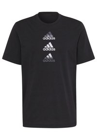 Černé tričko s krátkým rukávem Adidas s třemi naskládanými reflexními logy Adidas tištěnými svisle na přední části uprostřed.