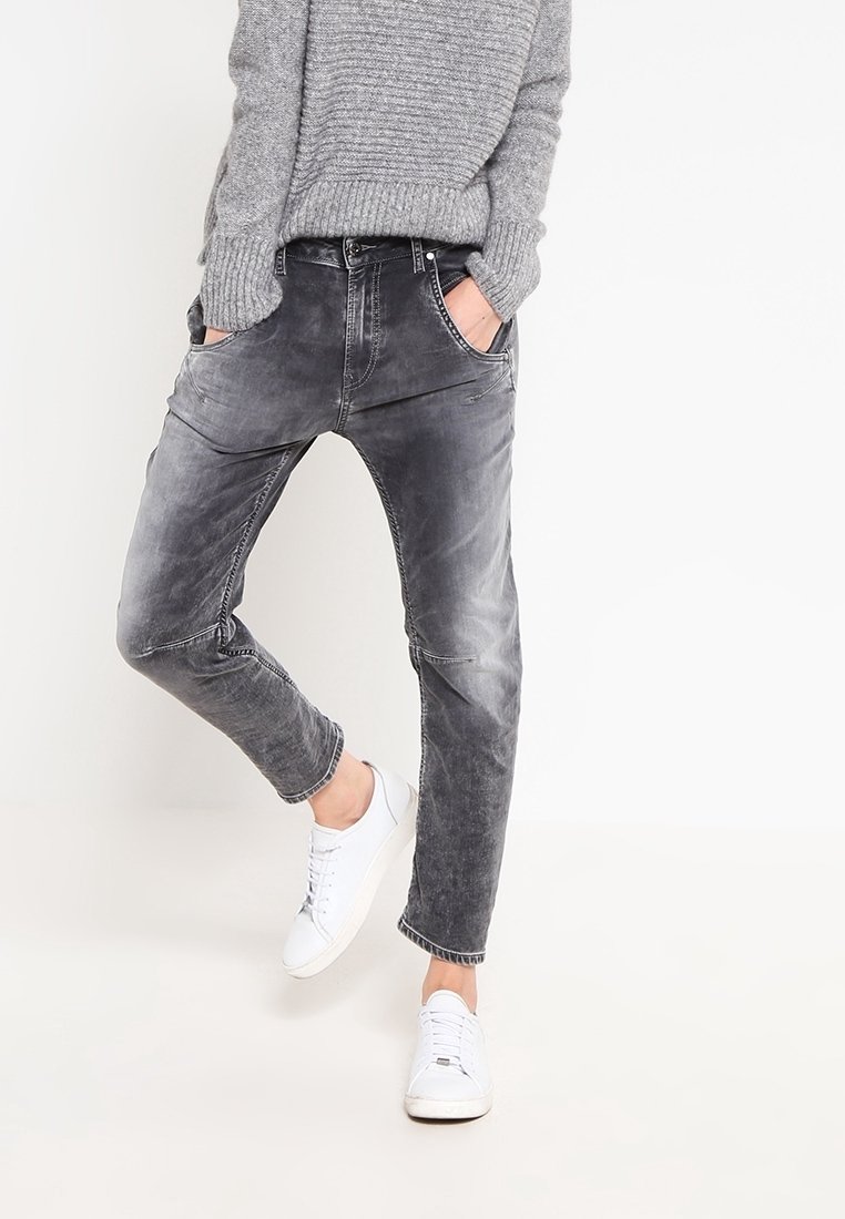 Gray, faded jeans with a relaxed fit, five pockets, and subtle whiskering details, paired with white sneakers. Soft denim texture.