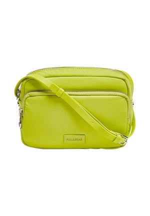 Fel limegroene crossbodytas met twee ritsvakken en een verstelbare schouderriem, met merknaam "PULL&BEAR" op het voorvak.