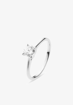 Silberner Solitärring mit einem einzelnen rund geschliffenen Diamanten, der von vier Krappen auf einem schlichten Band gehalten wird.