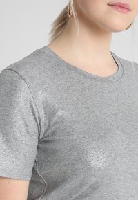 Gray short-sleeve t-shirt made of soft fabric, featuring subtle metallic accents. Round neckline and standard fit with minimal texture detail.