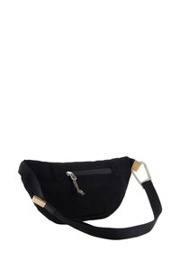 Riñonera de tela negra con superficie texturizada, bolsillo frontal con cremallera y acento de corcho. Presenta una correa ajustable y herrajes metálicos.