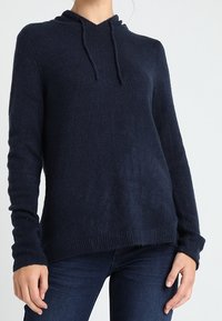 Marinblå huvtröja i mjukt material, med avslappnad passform, långa ärmar samt ribbade mudd och fåll.