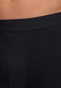Schwarze Sportshorts mit einem strukturierten Bund, der mit "MERRELL" geprägt ist. Glattes Gewebe, klassischer Schnitt und minimalistisches Design ohne Muster.