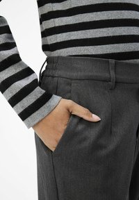 Gray trousers with a textured finish, featuring a side pocket and an elastic waistband. The upper garment has black and gray horizontal stripes.