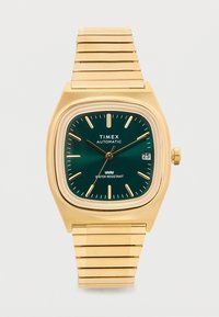 Reloj de pulsera automático Timex en tono dorado con esfera verde, marcadores de hora dorados, agujas, ventana de fecha a las 3 en punto y correa de metal enlazada.