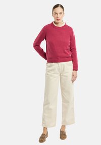 Maglione lavorato a maglia fucsia con collo rotondo, abbinato a pantaloni palazzo avorio e scarpe slip-on con stampa leopardata.
