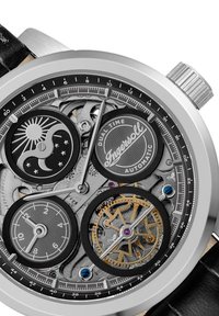 Zilveren automatische horloge met een zwarte leren band, voorzien van een doorzichtige wijzerplaat die ingewikkelde tandwielen, dubbele tijdsaanduidingen en twee subdials toont.