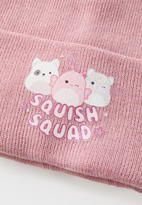 Tissu tricoté rose avec trois personnages animaliers de dessin animé et le texte "SQUISH SQUAD" en lettres épaisses et brillantes.