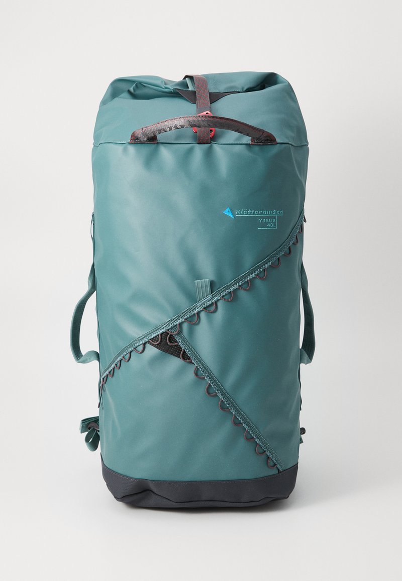 Teal waterproof backpack with a roll-top design, featuring a scalloped trim, side pockets, and a sturdy handle. 40L capacity.