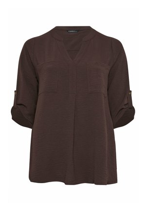 Blusa marrone scuro a maniche lunghe con maniche arrotolate, patte con bottoni, scollo a V e due tasche sul petto su tessuto strutturato.
