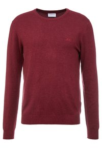 Tummanpunainen pyöreäkauluksinen neule, valmistettu pehmeästä kankaasta, jossa on pitkät hihat ja pieni kirjailtu logo rinnassa. Klassinen istuvuus ja sileä pinta.