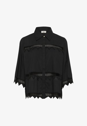 Černá polokošile s krátkým rukávem a špičatým límečkem, s horizontálními prostřihy a cik-cak prvky na lemech. Vyrobena z lehkého materiálu.