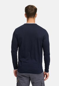 Long-sleeve navy blue shirt with a round neckline and white accent along the collar, made from soft cotton material.