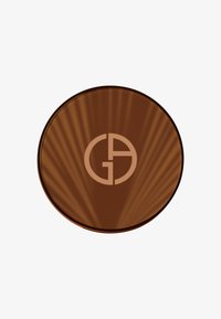 Compact en bronze avec texture rayonnante et forme circulaire. Présente un logo proéminent au centre. Fini lisse avec une surface réfléchissante.