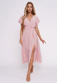 Rosa Wickelkleid mit kurzen Ärmeln, V-Ausschnitt, gebundenem Taillenband und seitlicher Schlitze. Der glatte, leichte Stoff sorgt für eine fließende Silhouette.