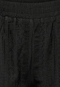 Tissu noir avec des rayures verticales texturées et des motifs brodés semblables à de la dentelle en rangées alternées.
