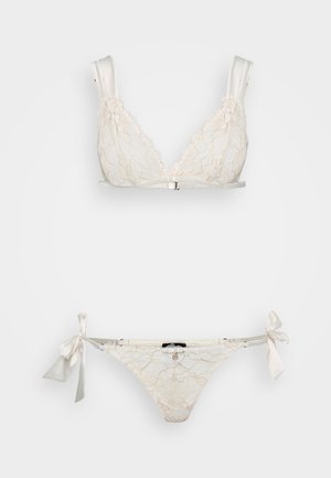 Spitzen-BH in Creme mit dreieckiger Form und Satinträgern, kombiniert mit passenden Bikinis mit seitlichen Bändern und zarten Mustern.
