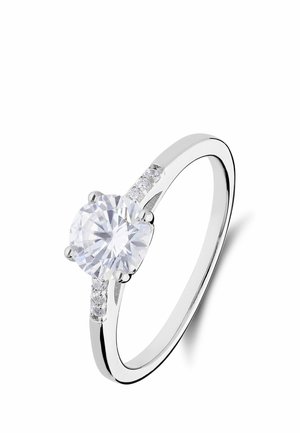 Silver engagement ring with a round brilliant-cut diamond center stone and smaller diamonds embedded on the band sides.
