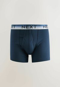 Boxer homme bleu marine avec ceinture élastique argentée affichant le nom de la marque « NEXT » en lettres noires.