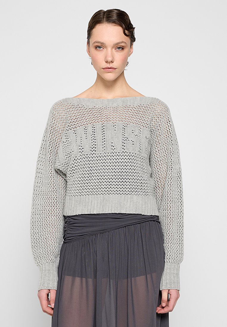 Grauer gestrickter Pullover mit einem offenen, lockeren Maschenbild, weitem Ausschnitt und langen Ärmeln. Besitzt einen auffälligen Strickschriftzug auf der Vorderseite.