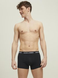 Schwarze Boxershorts mit einem weißen elastischen Bund, auf dem das Logo "JACK & JONES" prangt. Hergestellt aus weicher Baumwolle mit passender Passform.