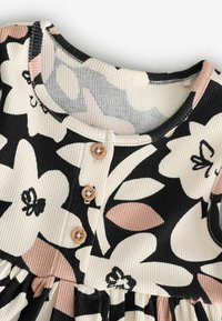 Vestito in tessuto a coste con grande stampa floreale nera, bianca e rosa, scollo rotondo, tre bottoni di legno e cucitura arricciata in vita.