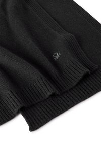 Tejido de lana negra con textura acanalada, que presenta un pequeño logo. El material parece suave y ligeramente esponjoso, con costuras cuidadas.