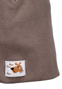 Ruskea neulepipo, jossa on graafinen etiketti, jossa on koiran kuva ja teksti "How How How" ruskealla. Tekstuuri on ribattoitu.