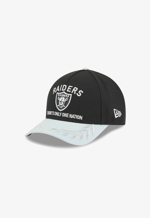 Schwarze Baseballmütze mit dem gestickten Schriftzug "RAIDERS" in Weiß, versehen mit einem silbernen Schirm im Blättermuster. Enthält das Teamlogo und den Spruch "ES GIBT NUR EINE NATION."