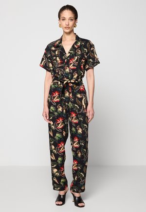 Combinaison noire à manches courtes, dotée d'un imprimé tropical vibrant. Le tissu est léger avec une taille ceinturée et un pantalon ample.