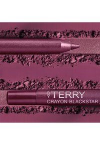 Crayon per trucco viola con punta glitterata e corpo liscio, circondato da polvere sbriciolata dello stesso colore, etichettato "BY TERRY CRAYON BLACKSTAR."