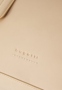 Beige lederen tas met het reliëf "bugatti" logo en verfijnde stiksels. Gladde textuur met een minimalistisch ontwerp.