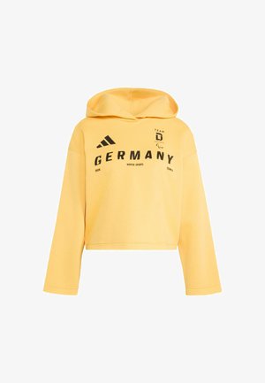 Żółta krótka bluza z miękkiego materiału z nadrukiem z przodu. Posiada kaptur ze sznurkiem i długie rękawy. Czarny tekst i akcenty z logo.