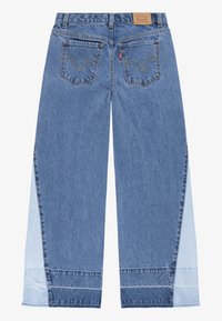 Wide-leg blue denim jeans featuring a two-tone design with lighter side panels, double back pockets, and contrasting stitching details.