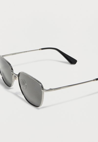 Ορθογώνια γυαλιά ηλίου με ασημένιο μεταλλικό σκελετό, σκουρόχρωμους φακούς και μαύρες άκρες στα κτενάκια, με τη σήμανση Burberry στο πλάι.